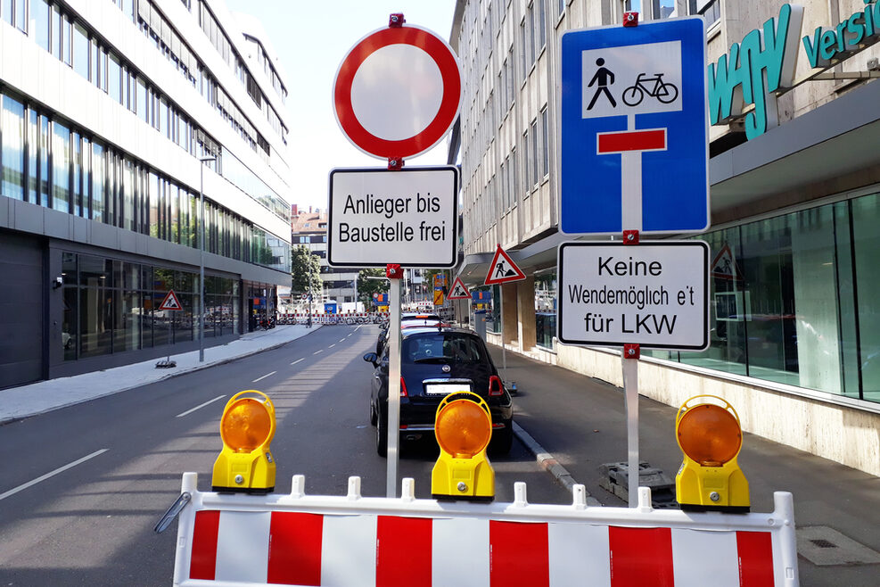 Ein Straße in Stuttgart mit verschiedenen Baustellenschildern.