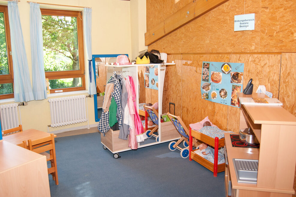 Der Rollenspielbereich ist ausgestattet mit einer Kinderküche, verschiedene Kleider und Babypuppen.