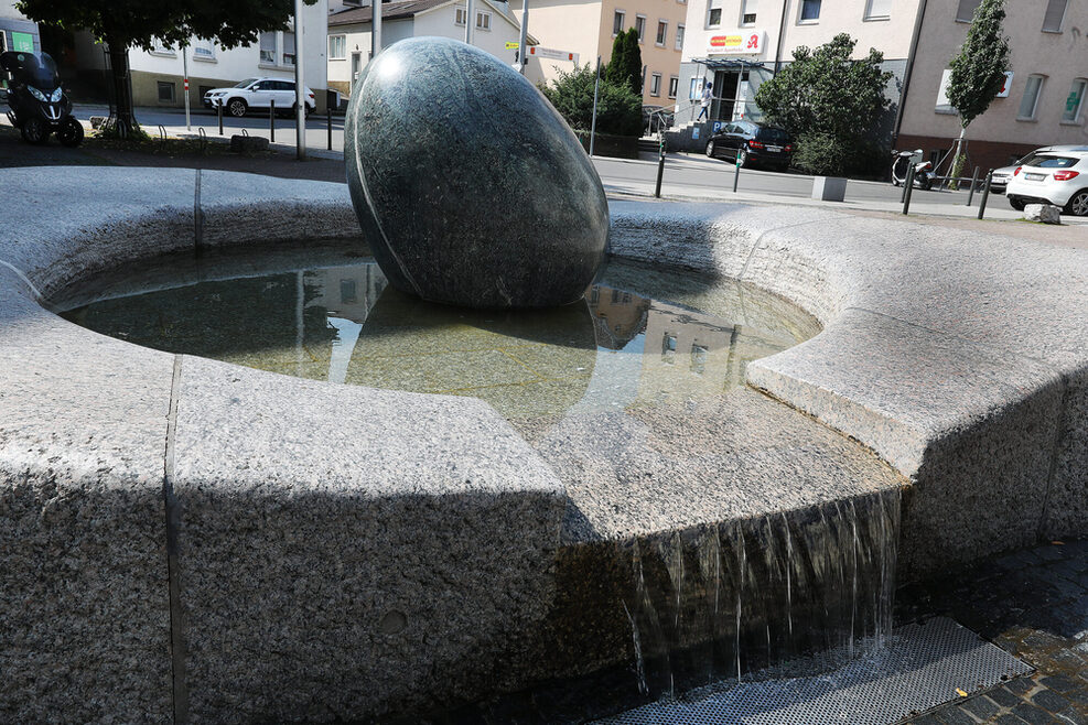 Kugel aus Stein in einem Brunnen.