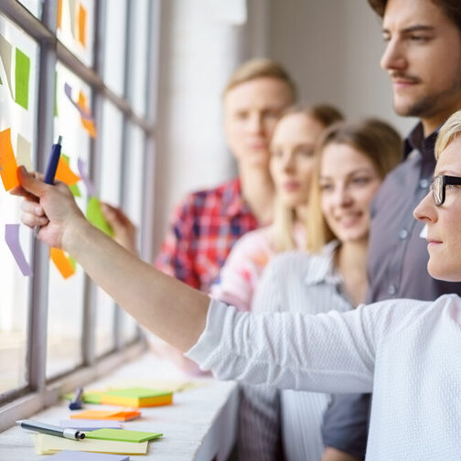 Work colleagues discussing ideas with sticky notes