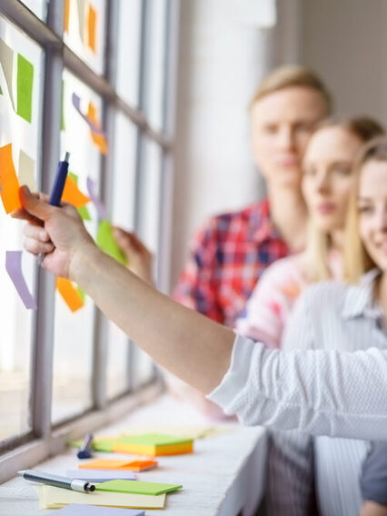 Work colleagues discussing ideas with sticky notes