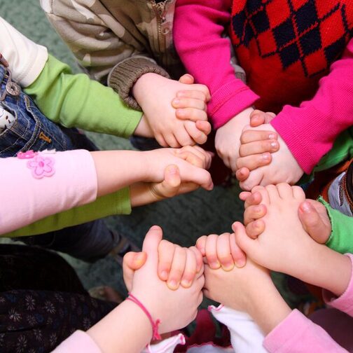 Eine Gruppe von Kindern fasst sich an den Händen.