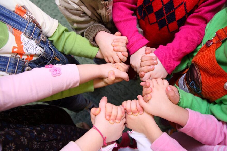 Eine Gruppe von Kindern fasst sich an den Händen.