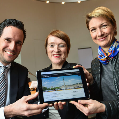 Erster Bürgermeister Dr. Fabian Mayer, die Beauftragte für Menschen mit Behinderung Simone Fischer und Sozialbürgermeisterin Dr. Alexandra Sußmann halten gemeinsam ein Tablet in der Hand.