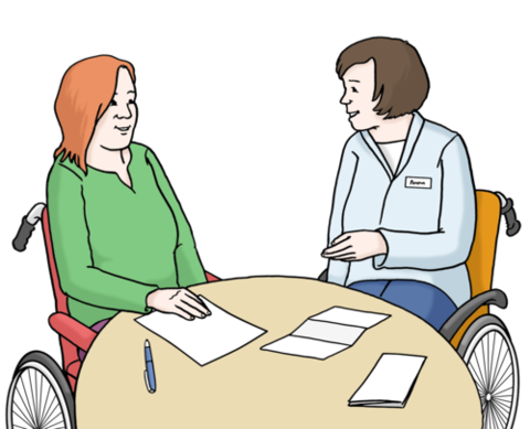 Zwei Frauen mit Rollstuhl sitzen am runden Tisch und sprechen miteinander.