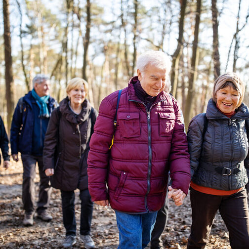 Ältere Menschen wandern durch den Wald.