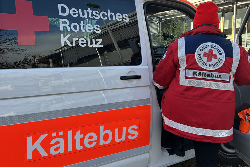A DRK employee boards the refrigerated bus
