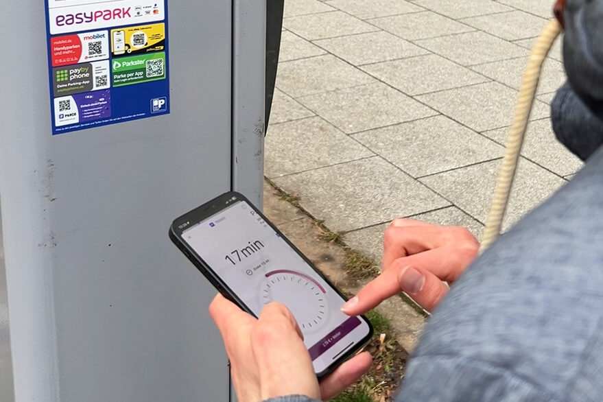 One person uses a parking app on their smartphone