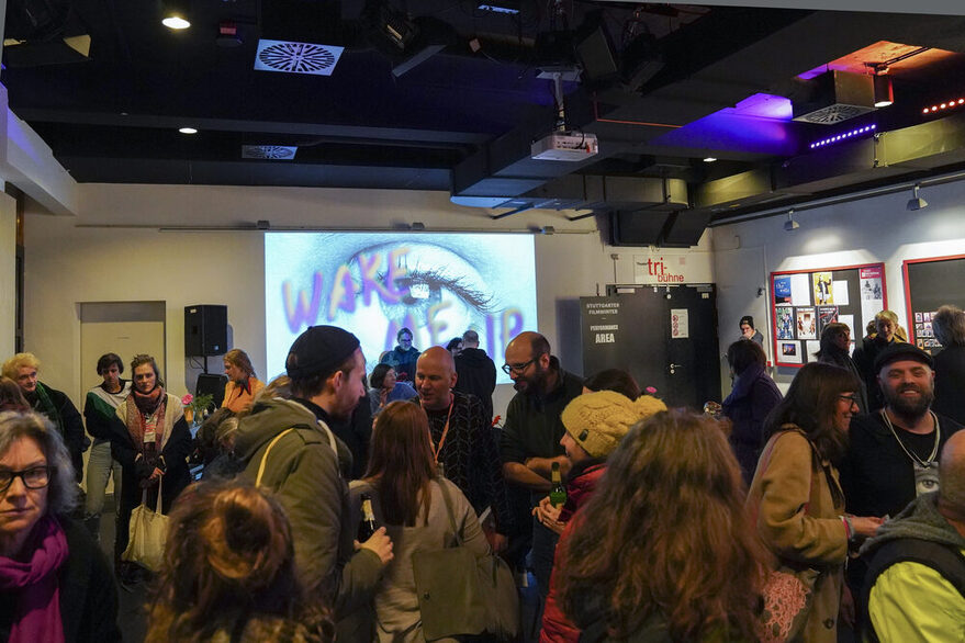 Besucher der Veranstaltung Filmwinter unterhalten sich in einem Raum.
