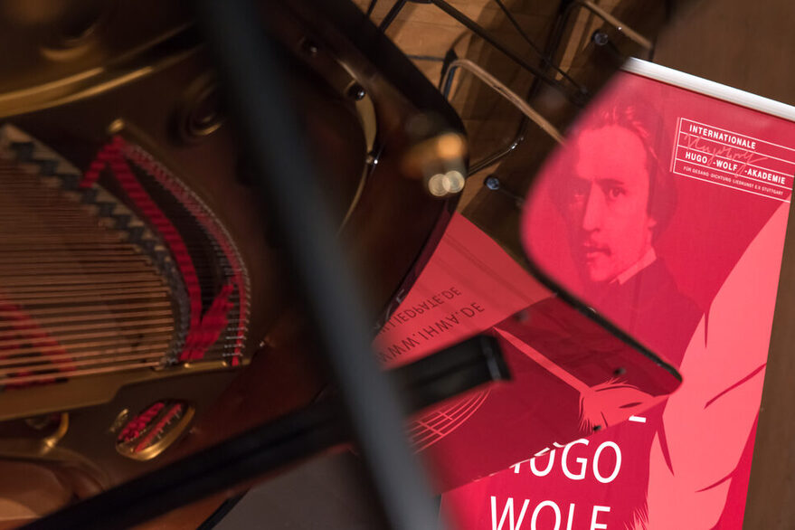 Teil eines Musikinstruments mit Plakat der Internationalen Hugo-Wolf-Akademie Stuttgart.