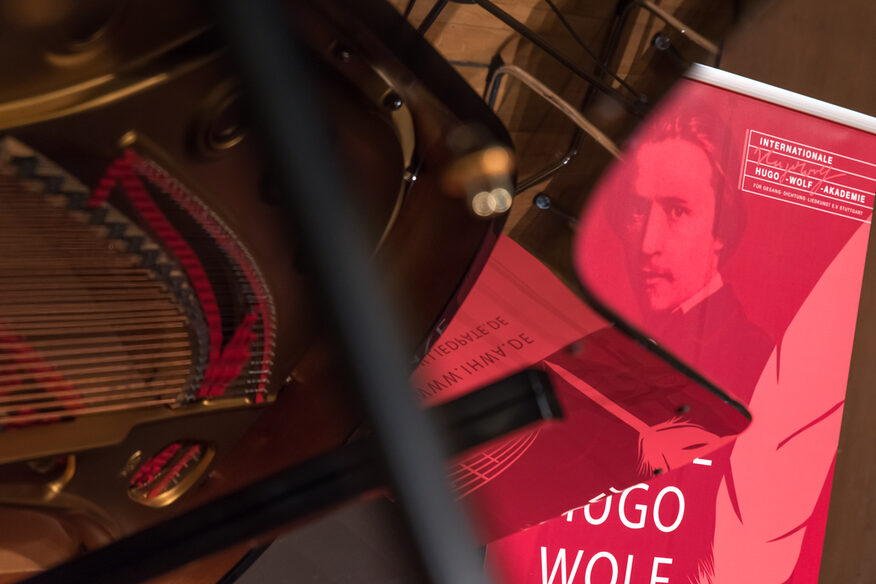 Teil eines Musikinstruments mit Plakat der Internationalen Hugo-Wolf-Akademie Stuttgart.
