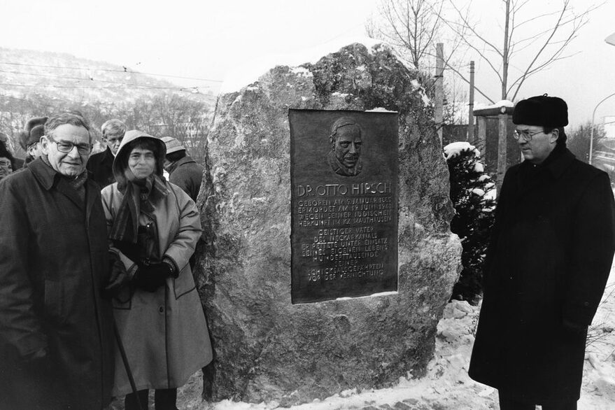 Mehrere Menschen stehen an der Gedenktafel für Otto Hirsch in Hedelfingen - darunter Manfred Rommel, ehemaliger Oberbürgermeister Stuttgarts.