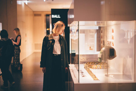 Visitor looks at exhibits in a glass case.