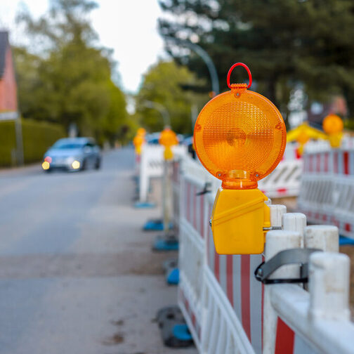 Blick in eine Straße mit einer Baustelle am Straßenrand.