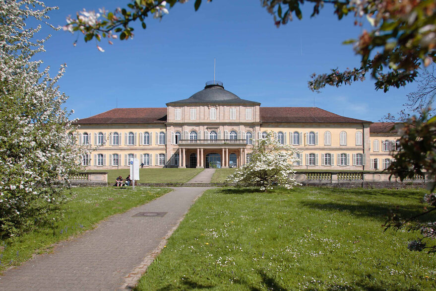 Blick auf das Schloss Hohenheim mit der Parkanlage im Vordergrund.