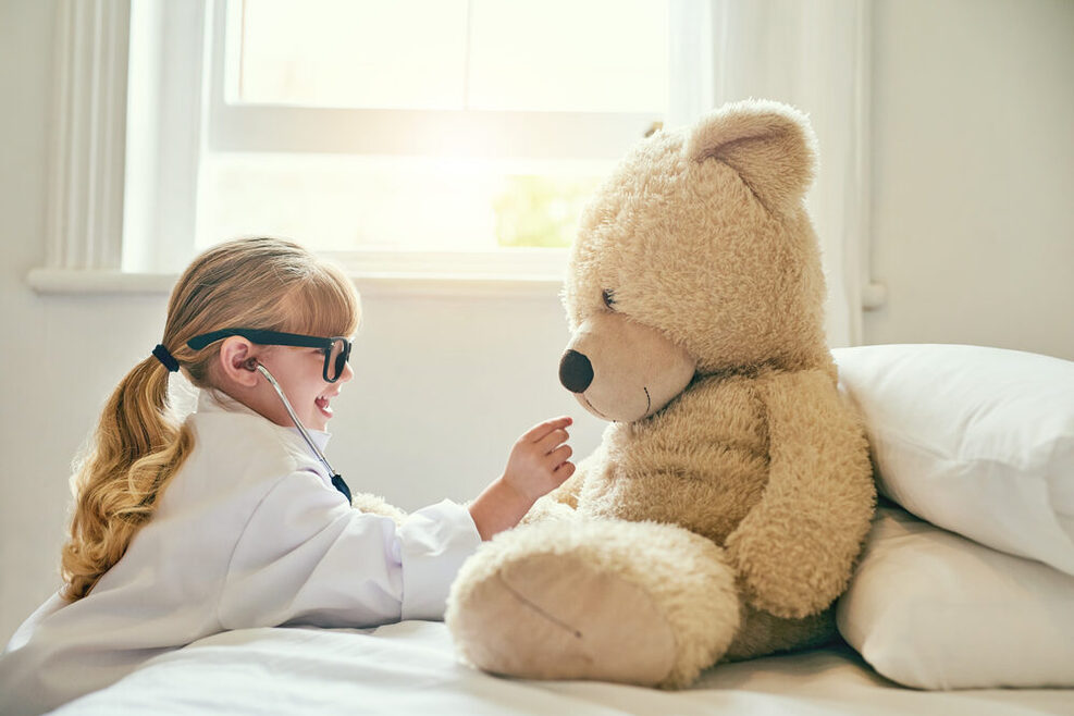 Als Ärztin verkleidetes Mädchen untersucht Teddybär.
