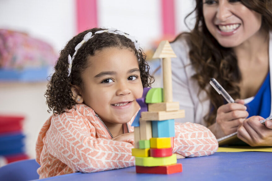 Little girl building with blocks.