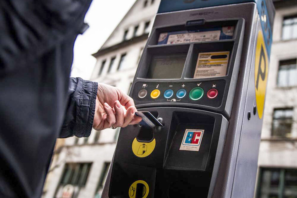Ein Mann bezahlt mit einer EC-Karte an einem Parkscheinautomat.