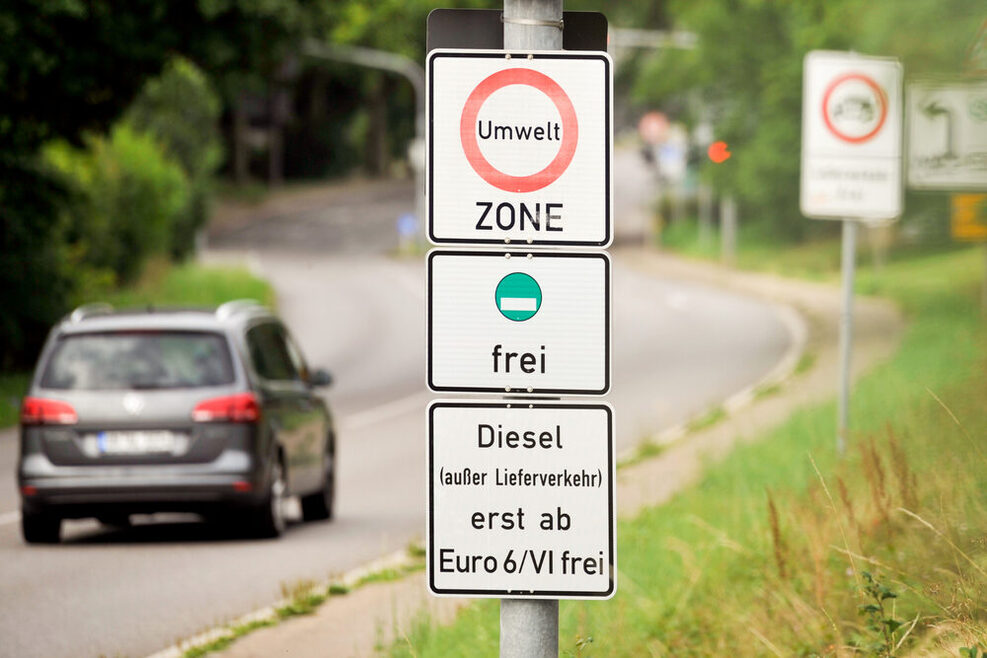 Autos fahren auf einer Straße an einem Verkehrsschild zum Dieselverkehrsverbot vorbei.