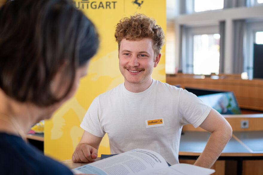 Ein Mitarbeiter der Landeshauptstadt berät eine Bürgerin zur Elektromobilität