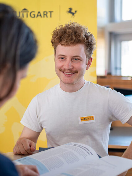 Ein Mitarbeiter der Landeshauptstadt berät eine Bürgerin zur Elektromobilität