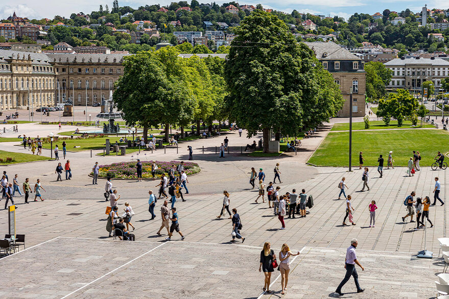 Zahlreiche Menschen sind auf dem Schlossplatz unterwegs bei gutem Wetter.