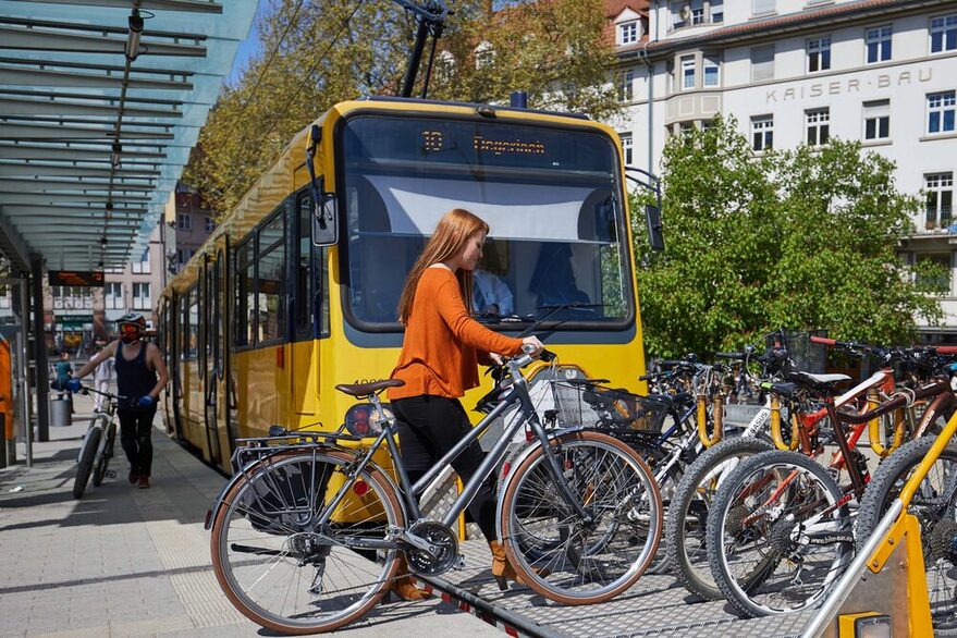 Junge Frau stellt ihr Fahrrad auf den Fahrradwagen der Zahnradbahn.