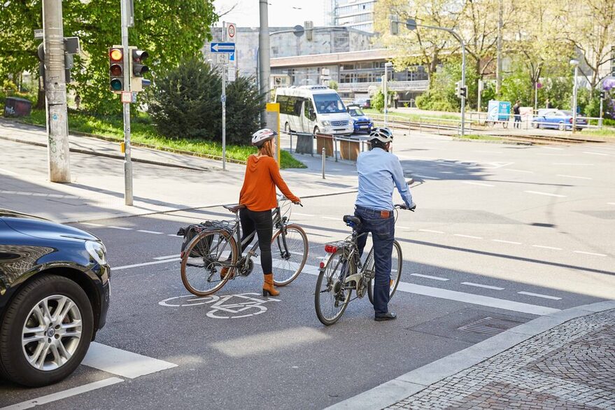 Zwei Frahhradfahrer stehen an einer Ampel.