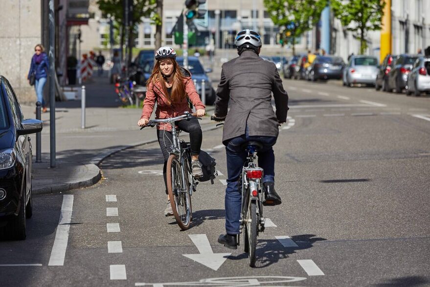 Eine Mann fährt als Geisterradler auf einem Fahrradweg, eine Fahrradfahrerin kommt ihm entgegen.