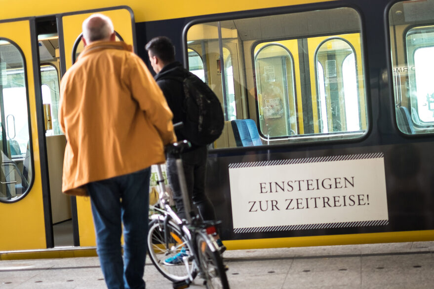 Ein Mann steigt mit seinem Fahrrad in eine Stadtbahn.