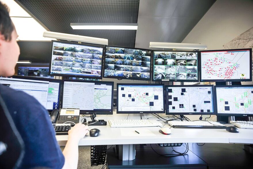 Arbeitsplatz in der Integrierten Verkehrsleitzentrale. Mitarbeier sitzt vor vielen Monitoren, auf denen das Verkehrsgeschehen in Stuttgart abgebildet wird.der Integrierte Verkehrsleitzentrale IVLZ