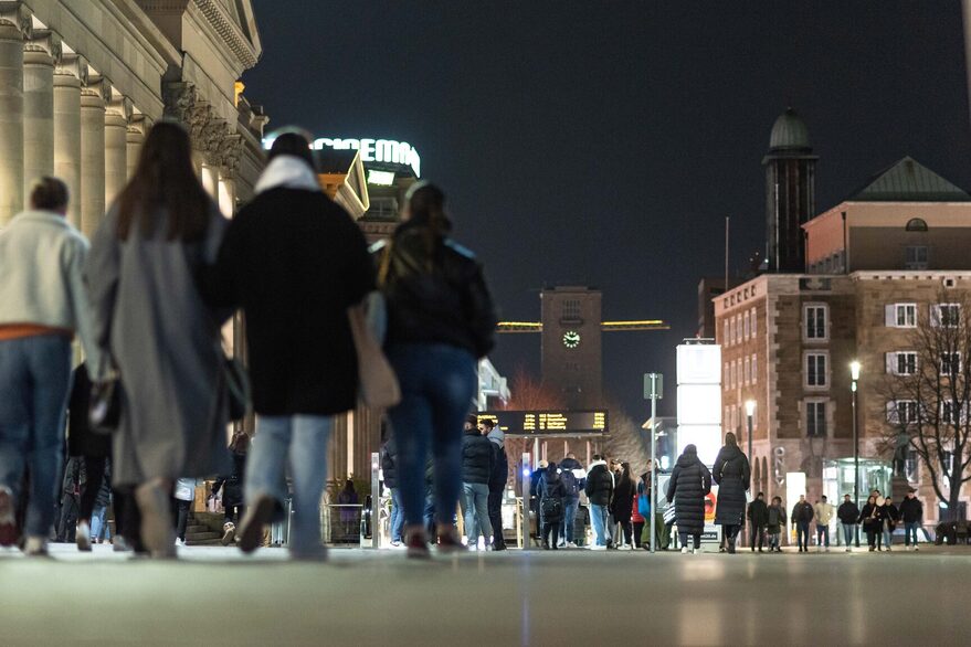 People walking on the Königstrasse at night.