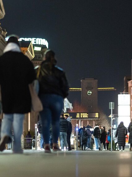 Menschen spazieren bei Nacht auf der Königstrasse.