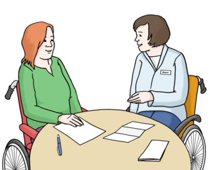 Zwei Frauen sitzen in einem Rollstuhl zusammen am Tisch und sprechen miteinander.