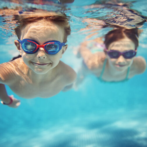 Unterwasserfoto von zwei Kindern, die tauchen.