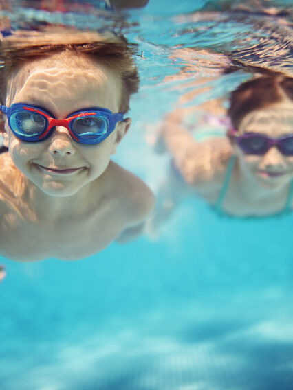 Unterwasserfoto von zwei Kindern, die tauchen.