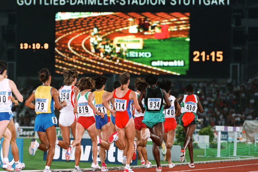 Eine Gruppe von Athlethen läuft im Stadion, im Hintergrund ist eine große Bildanzeige zu sehen sowie die Aufschrift "Gottlieb-Daimler-Stadtion Stuttgart".