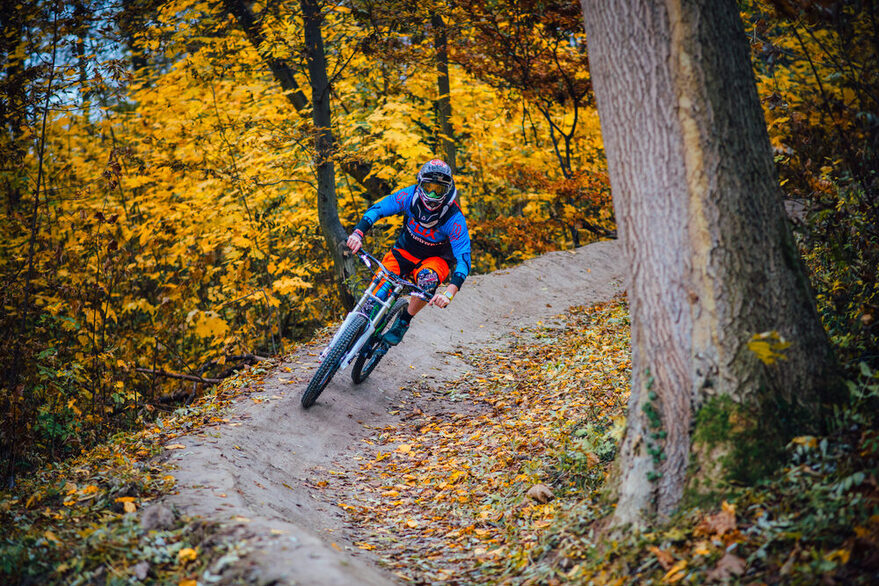 Radfahrer fährt auf einer Downhill-Strecke durch den Wald.