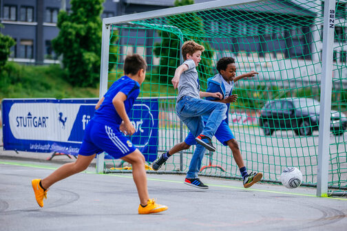 Drei Jungen spielen Fußball.