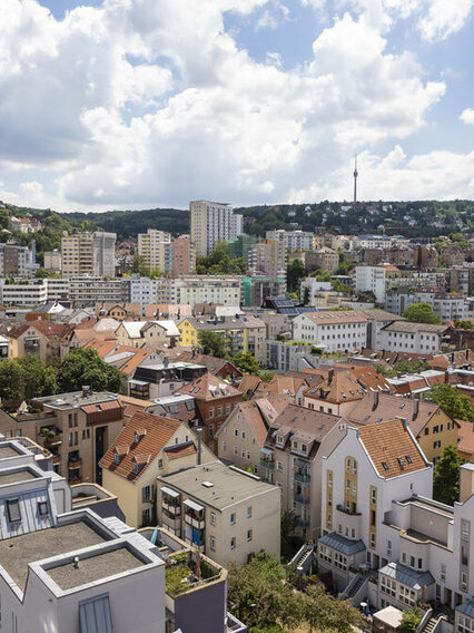 Blick auf mehrere Häuser, im Hintergrund Wald und der Fernsehturm.