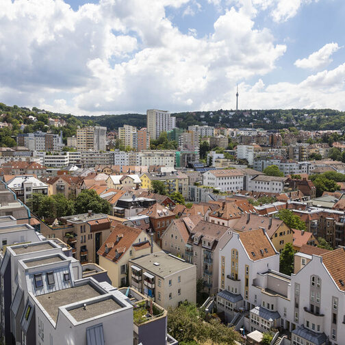 Blick auf mehrere Häuser, im Hintergrund Wald und der Fernsehturm.