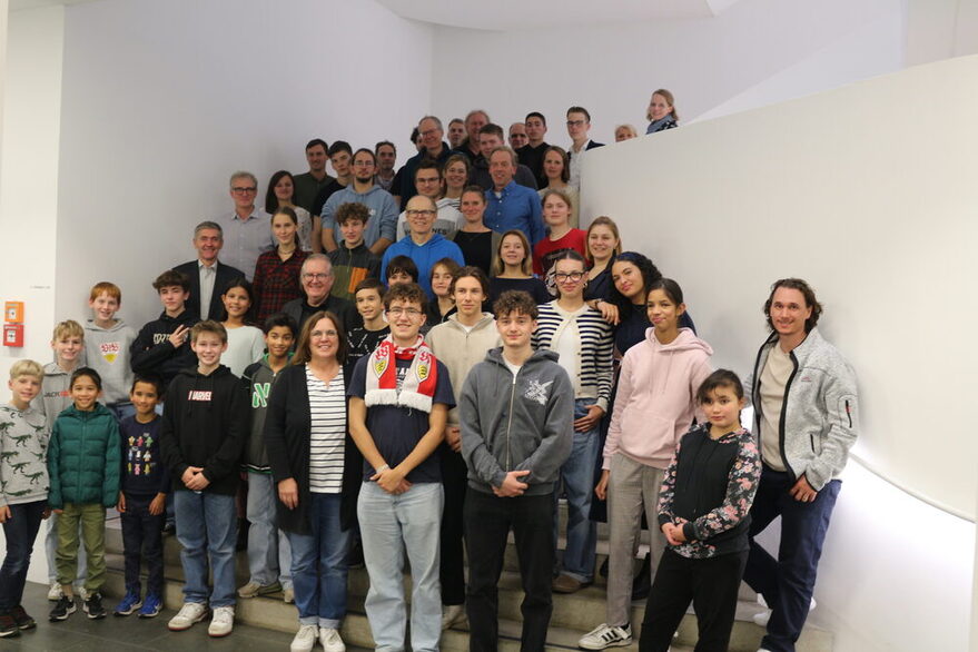 Rund 30 Teilnehmer, Schülerinnen und Schüler, Lehrerinnen und Lehrer und vertreter der Stadtverwaltung (unter anderem Bürgermeister für  Städtebau, Wohnen und Umwelt, Peter Pätzold, Dr. Jürgen Görres als Leiter der Abteilung Energie und Sandra Lange) stehen auf einer Treppe im Stuttgarter Rathaus für das Gruppenbild.