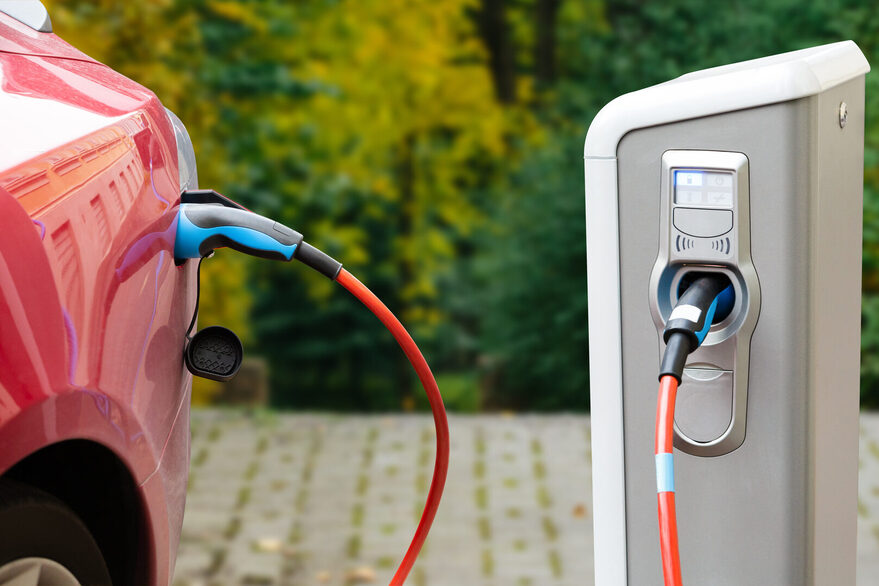 Nahaufname eines ladenden Elektrofahzeugs in rot an einer Ladesäule