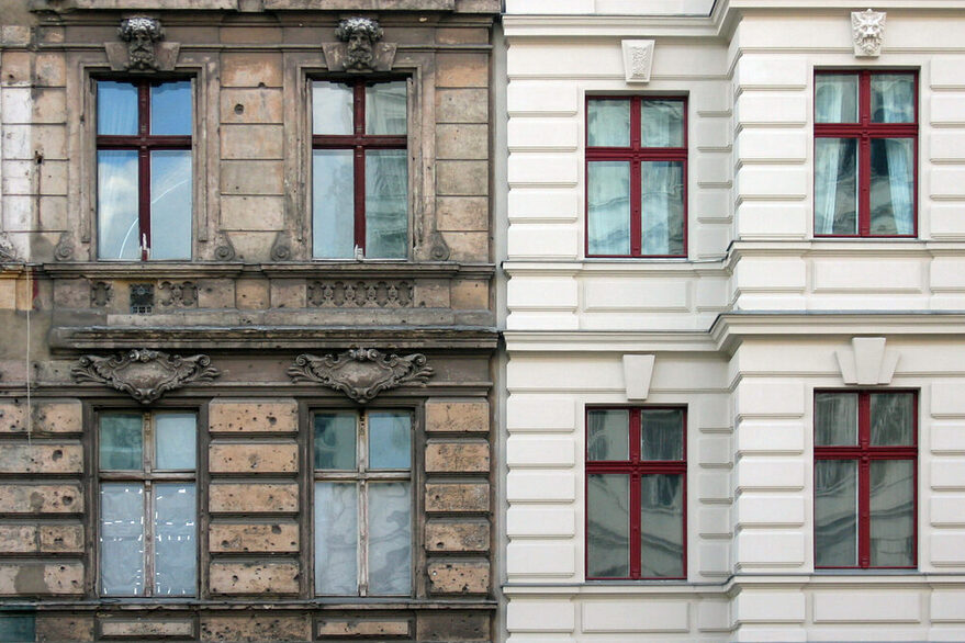 Auf dem Foto sind zwei baugleiche Gebäude zu sehen. Das linke Gebäude mit unsanierten Fenstern und unrenovierter Fassade. Das rechte Gebäude erstrahlt mit einer weißen Fassade und neuen Fenstern.
