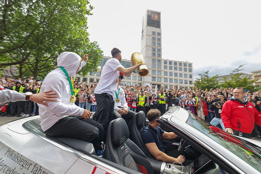 Das Foto zeigt den Mannschaftskapitän Atakan Karazor mit dem DFB-Pokal beim Autokorso auf dem Marktplatz in Stuttgart. Foto: Leif Piechowski/Stadt Stuttgart