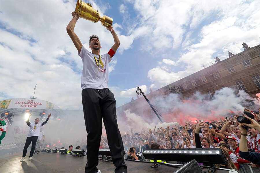 Das Foto zeigt den Mannschaftskapitän Atakan Karazor mit dem DFB-Pokal und einem Siegesruf auf der Tribüne auf dem Schlossplatz. Foto: Leif Piechowski/Stadt Stuttgart
