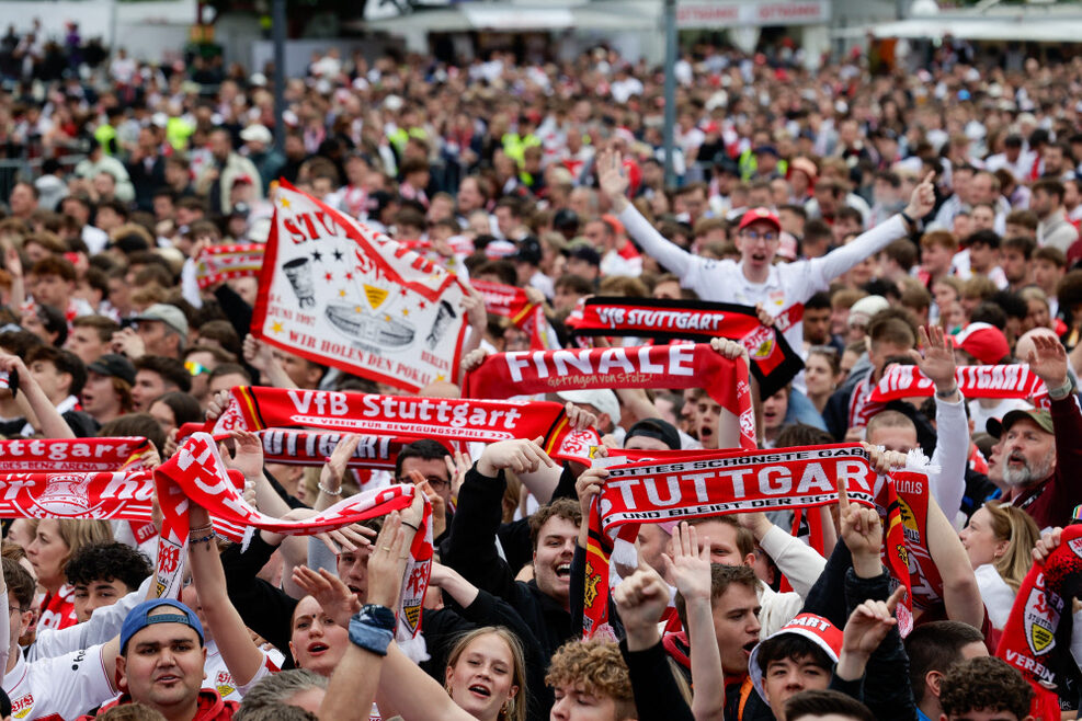 Feiernde VfB-Fans, die ihre Fan-Schals in die Höhe halten.