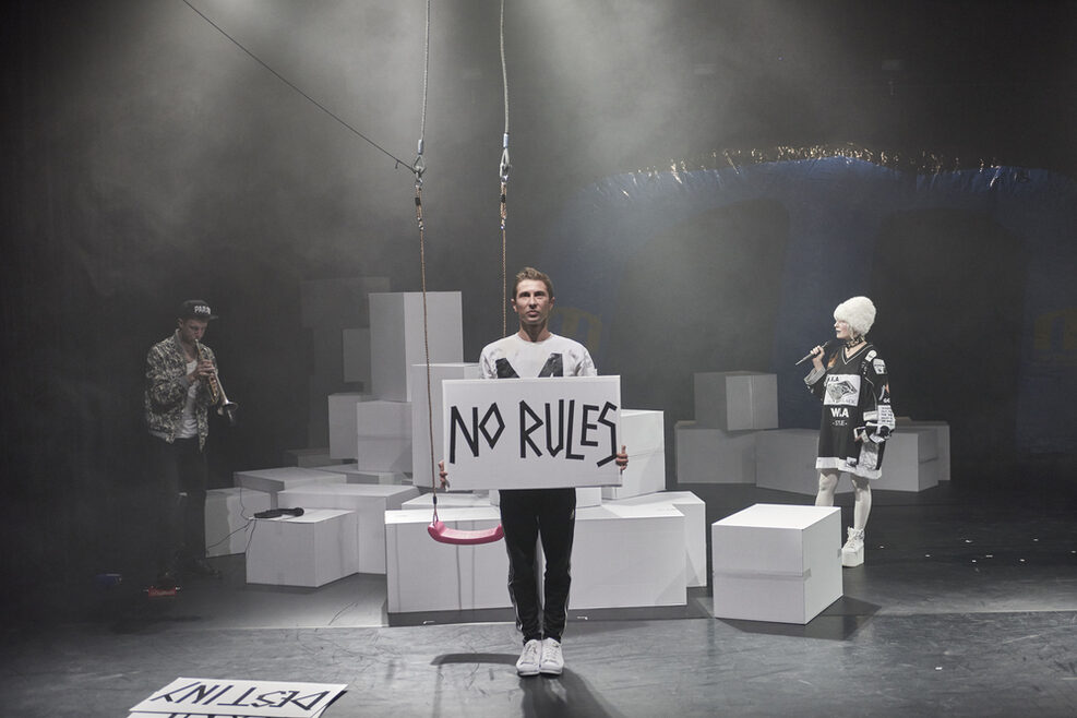 Ein Mann hält auf der Bühne ein Schild hoch: No rules