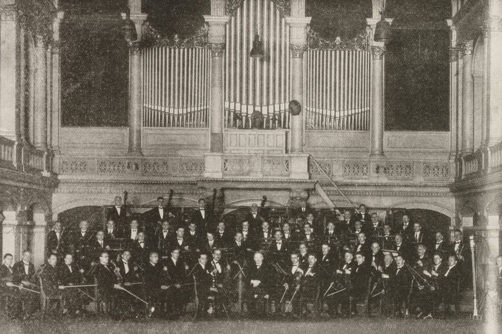 Orchestermusiker des Philharmonischen Orchesters Stuttgart sitzen in Formation vor der Orgel in der alten Liederhalle (1927)