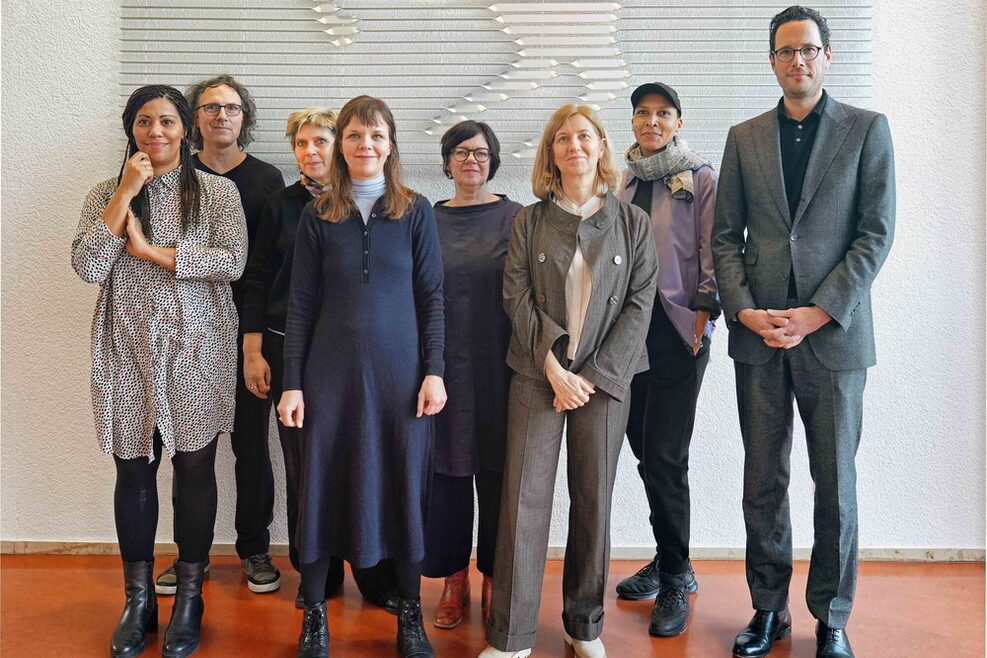 Gruppenfoto Erster Bürgermeister Dr. Fabian Mayer mit den kunstverständigen Jurymitgliedern im Rathaus Stuttgart vor einer weißen Wand.